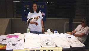 Katherine sells shirts with one of her chickens.